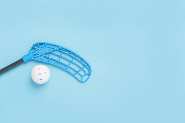 floorball stick and white ball isolated on blue background - Fotó, kép