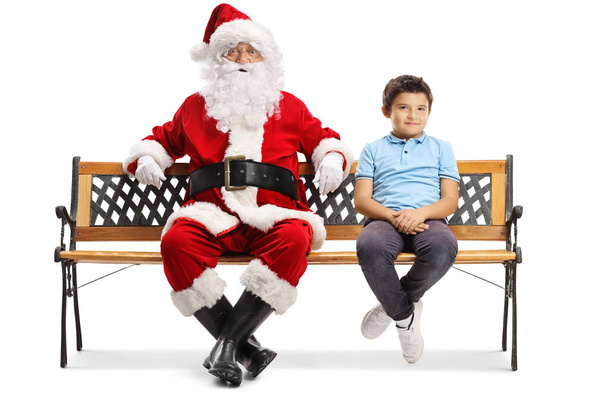 Santa sitting on a bench with a boy - Фото, зображення