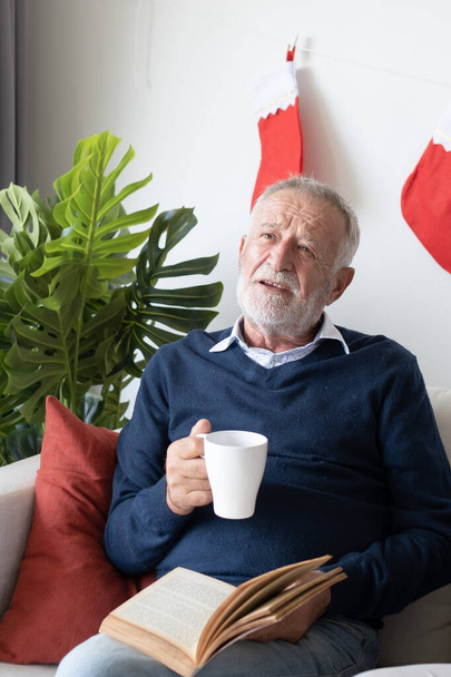 senior elderly caucasian old man drinking coffee with reading bo - Photo, Image