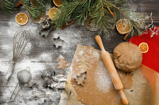 Cuisson de biscuits de Noël dans la cuisine, vue sur le dessus. Ambiance de Noël fond. Forme pour la cuisson, battledore, arbre de Noël, oranges, dasher, tamis pour la farine, pâte
. - Photo, image