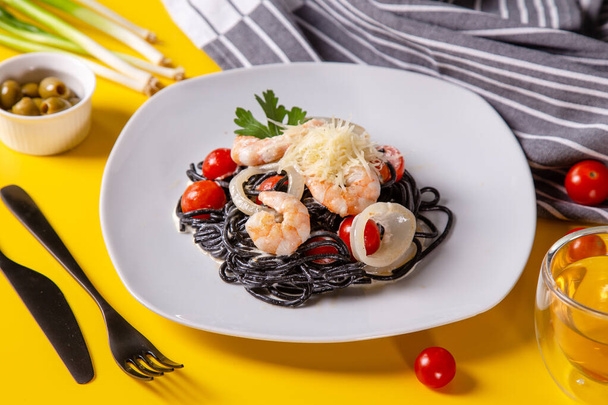 Fideos de espaguetis negros con mariscos
 - Foto, Imagen