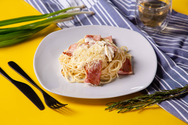 Pasta carbonara with bacon on white plate - Фото, изображение