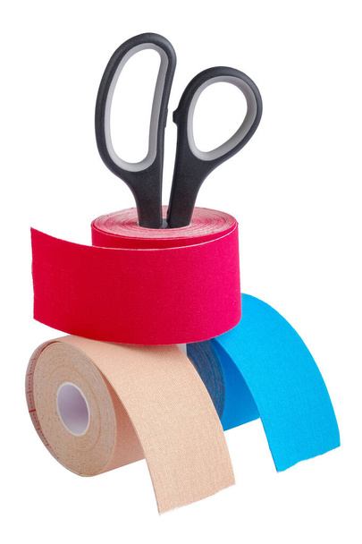 Stack ofthree rolls kinesiology tape for athletes and scissors isolated on white background. - Photo, Image