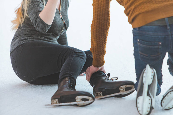 woman fall down while skating. man helping her - Фото, зображення