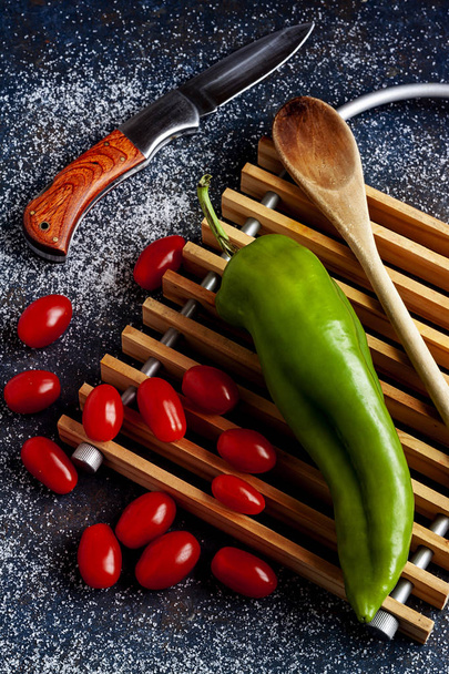 GREEN PEPPER WITH CHERRY TOMATOES WITH SALT AND WOOD SPOON - Photo, Image