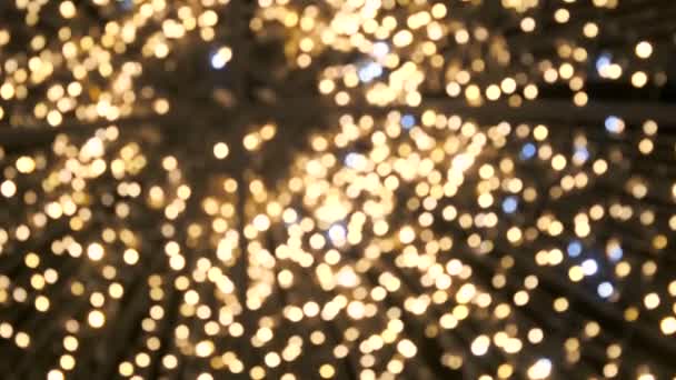 soft defocused new year holidays light abstract background with bokeh balls, out of focus flashing color lights at Christmas night. lens blur of bright winter party glittering lights of bulb garlands - Footage, Video