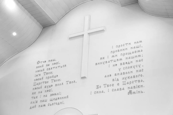Raamatun teema. Rukous Isä meidän ukrainaksi valkoisella seinällä
 - Valokuva, kuva