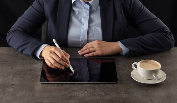 Geschäftsfrau arbeitet an Tablet mit dunklem Hintergrund - Foto, Bild