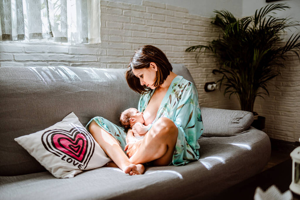 A newborn baby breastfeeding his mother. Family concept - 写真・画像