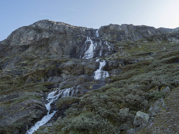Waterfall in mountains. National tourist scenic route 55 Sognefjellet between Lom and Gaupne, Norway. Blue sky background. - Photo, Image
