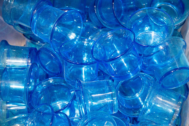 ein Bündel kleiner blauer Glasbecher zur Schau gestellt - Foto, Bild