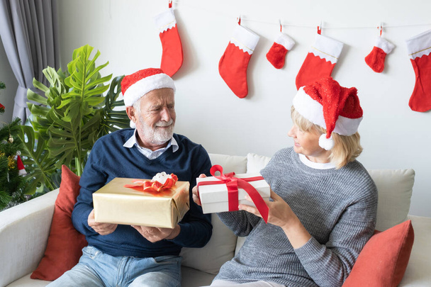 senior elderly caucasian old man and woman give gift presents to - 写真・画像