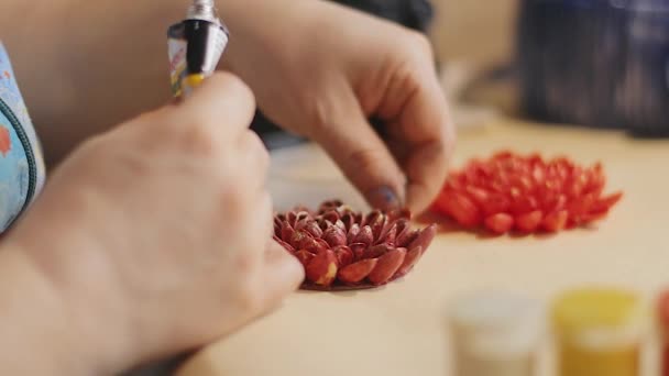 Artista femenina está haciendo un diseño de flores decorativas con conchas de nuez pintadas
 - Metraje, vídeo