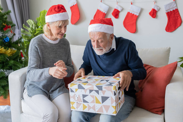 idoso idoso caucasiano velho homem e mulher ajudar a abrir grande presente pr
 - Foto, Imagem