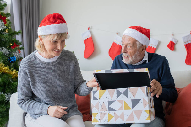 anziani anziani caucasico vecchio uomo e donna aiuto aprire grande regalo pr
 - Foto, immagini