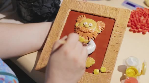 Künstlerin putzt das handgefertigte Gemälde vor dem Lackieren - Filmmaterial, Video