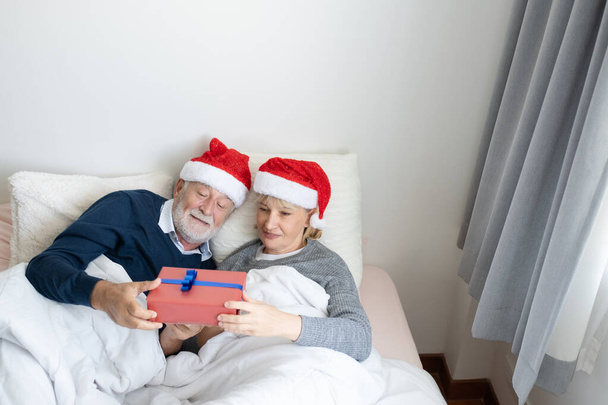 年配の白人男性が女性にプレゼントをする - 写真・画像