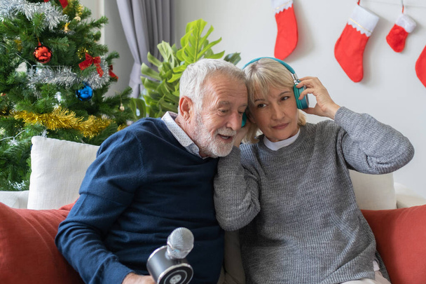 старший літній чоловік і жінка із задоволенням співають пісню і слухають
 - Фото, зображення
