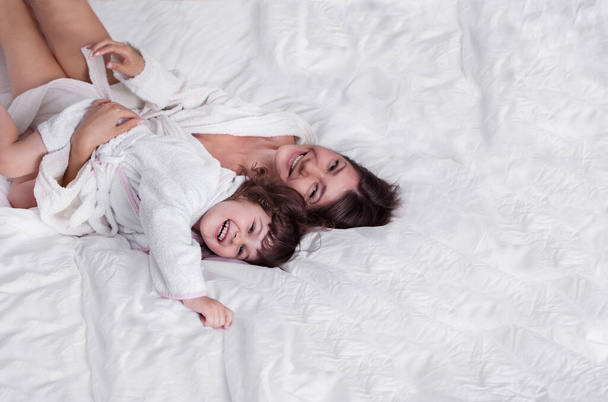 Mother with daughter have fun on the bed - Fotó, kép