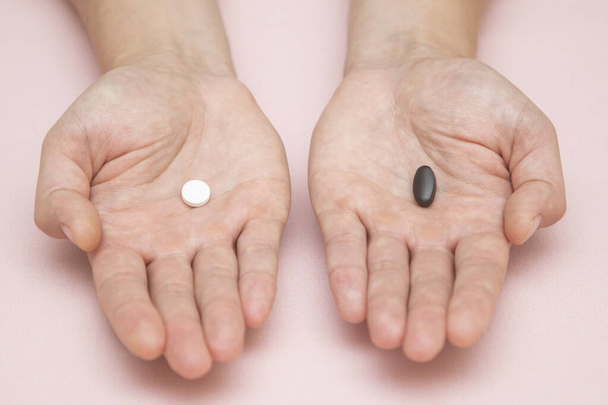 comprimido preto e branco, um homem dá uma escolha de comprimidos, nas palmas de suas mãos - Foto, Imagem