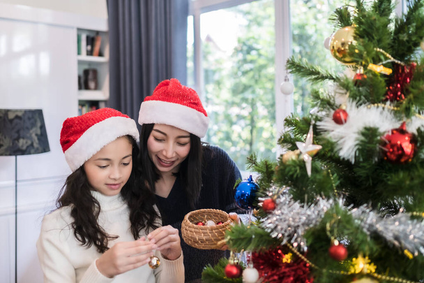 heureux famille, mère et fille aider à décorer cadeau, jouet, p
 - Photo, image