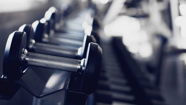 gym interior background of dumbbells on rack in fitness and work - Foto, imagen