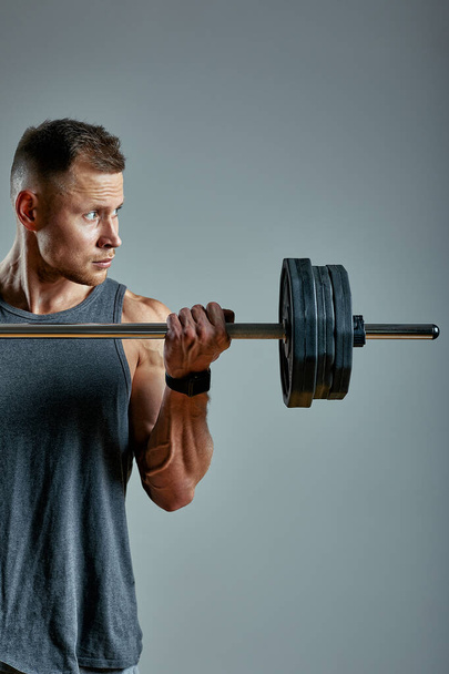 Man doing back workout, barbell row in studio over gray background. Copy space - Photo, Image