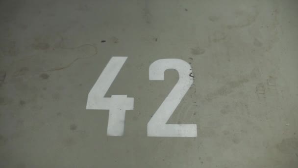 número 42 pintado en el piso del garaje
 - Metraje, vídeo