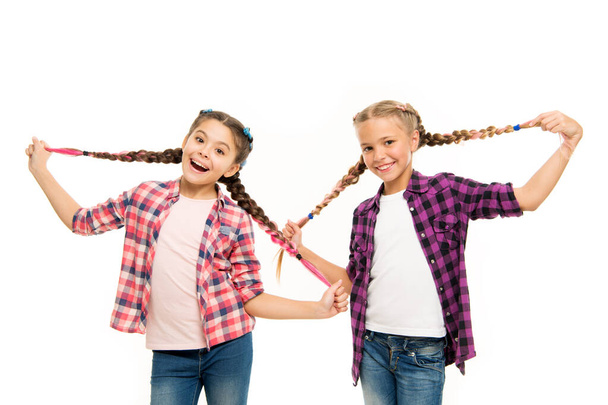 Such a long hair. Happy little girls wear plaited hair. Cute small childred hold hair braids. Luxurious hair extensions. Hairdressing salon for kids - 写真・画像