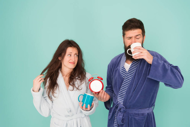 morning couple drink coffee. bearded man and girl coffee cup. wake up time. family life routine. Sleep disorders. couple in love alarm clock. Insomnia effects. tea time at home. hard morning - Foto, imagen