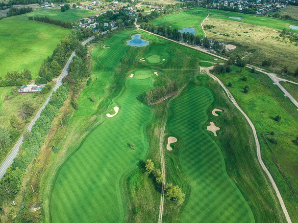 Golf kulübünün, yeşil çimenlerin, ormanların, çim biçme makinelerinin havadan çekilmiş fotoğrafları. - Fotoğraf, Görsel