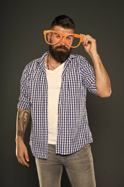 Funny hipster in extravagant glasses. Fashion man with beard. Playful guy enjoying party. Funny glasses accessory. Entertaining himself. Only fun on my mind. Bearded man wearing party glasses - Photo, image