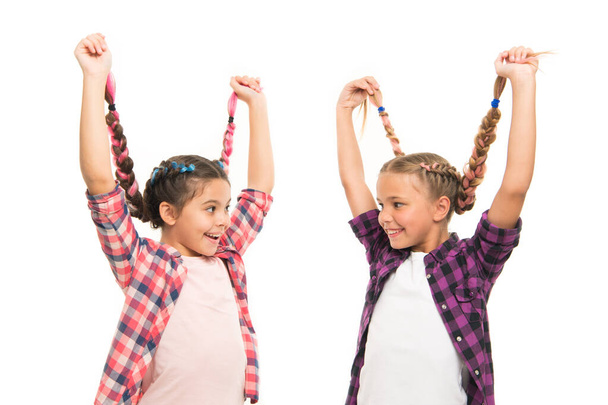 Create simple but gorgeous hairstyle. Happy children wear plaited hairstyle. Small cute girls hold long braids hairstyle. Give hairstyle free-spirited look. Hair salon - Foto, imagen