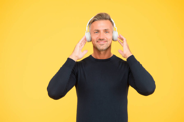 mature man enjoy music. autotraining. his favorite playlist. party in earphones. happy man yellow background. listen to music in headphones. catch the tune. audio book listening. online education - Photo, Image