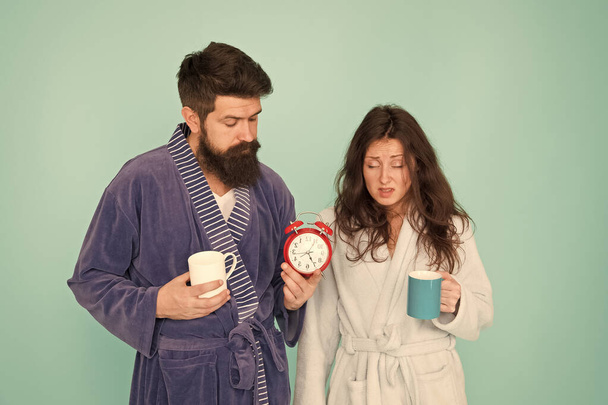 Its coffee time. Every morning begins with coffee. Couple in bathrobes with mugs. Man with beard and sleepy woman enjoy morning coffee or tea. Guy in bath clothes hold tea coffee. Breakfast concept - Foto, immagini