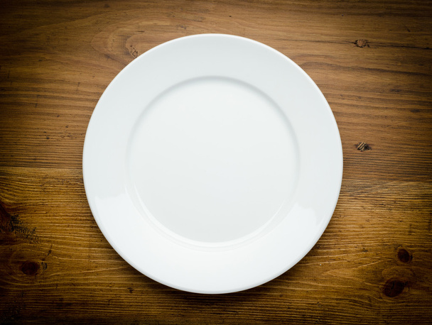 Empty white plate on wooden table - Fotografie, Obrázek
