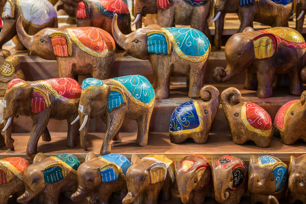 Close-up widok rzeźbionych drewnianych słoni sprzedających się w stoisku z pamiątkami na Ratchada Rot Fai Train Night Market Bangkok, Tajlandia. - Zdjęcie, obraz