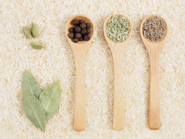 Spices in spoon on background from basmati rice ��� green cardam - 写真・画像