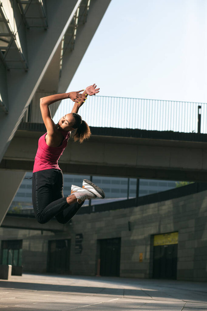 Beautiful professional athlete jumping high in the air outdoors - Valokuva, kuva