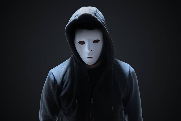 Masked anonymous hacker on black background. - Foto, Bild