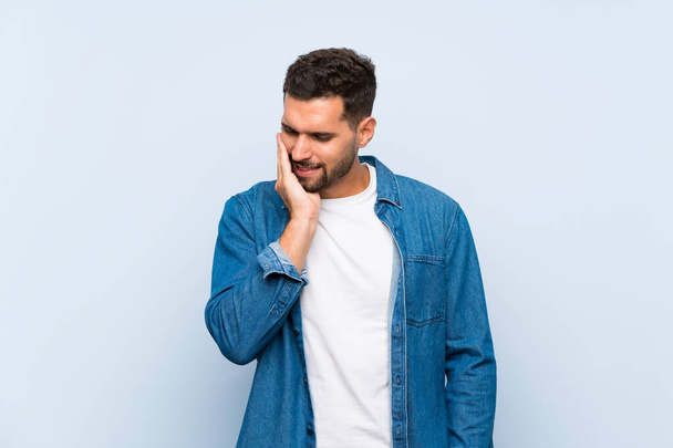 Handsome man over isolated blue background with toothache - Φωτογραφία, εικόνα