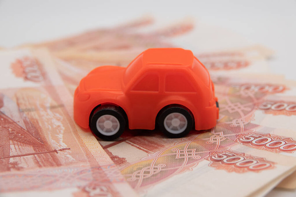 покупка автомобиля в рублях игрушечный автомобиль на фоне банкнот
. - Фото, изображение