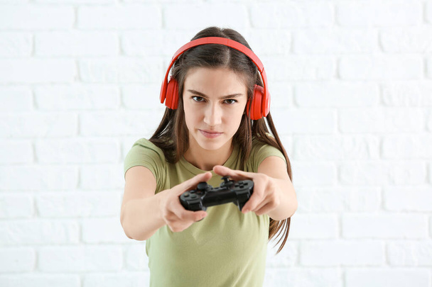 十代の女の子とともにゲームパッド上のホワイトレンガの背景 - 写真・画像