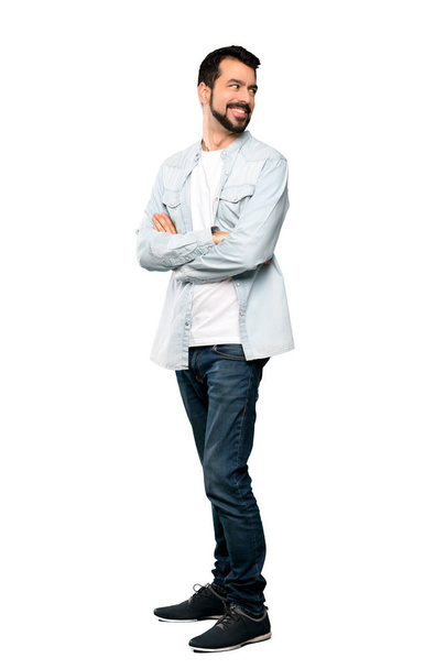 Full-length shot of Handsome man with beard with arms crossed and happy over isolated white background - Valokuva, kuva