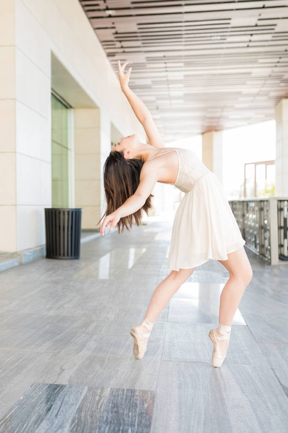 Великолепная балерина репетирует танцевальный номер на улице
 - Фото, изображение