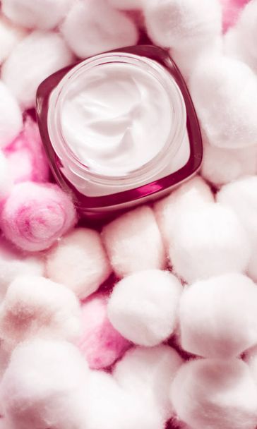 Luxe gezichtscrème voor de gevoelige huid en roze katoenen ballen op ba - Foto, afbeelding