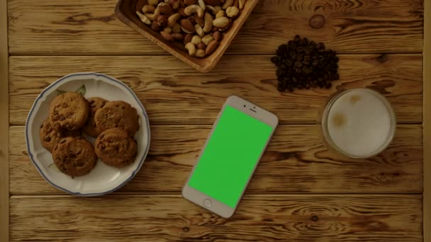 Smartphone κοντά μπισκότα και καφέ το πρωί - Πλάνα, βίντεο