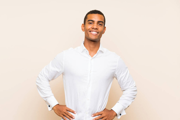 Young handsome brunette man over isolated background posing with arms at hip and smiling - Φωτογραφία, εικόνα
