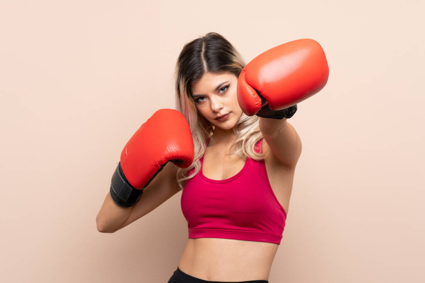 Teenager Sportmädchen über isolierten Hintergrund mit Boxhandschuhen - Foto, Bild
