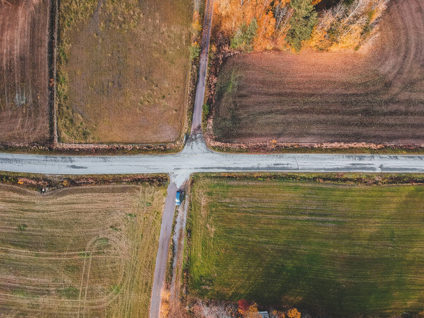 Vista aérea de la intersección de dos caminos rodeados de campos. Foto tomada de un dron. Finlandia, Pornainen
. - Foto, Imagen
